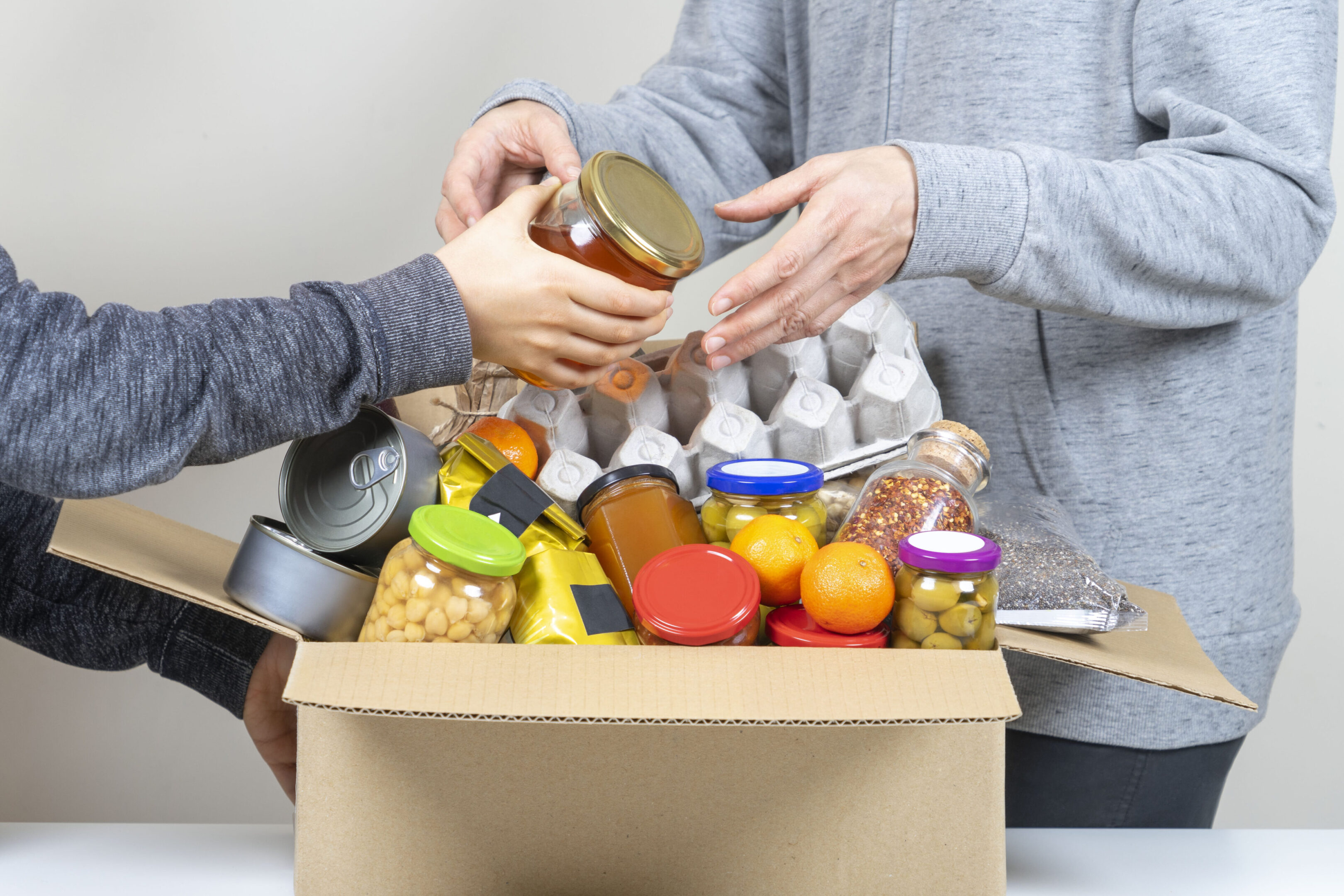 A box of food is being handed out to people.