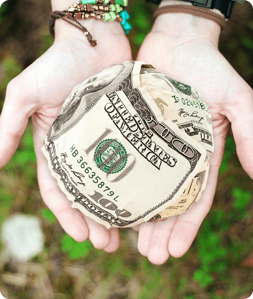 A person holding a ball made of money