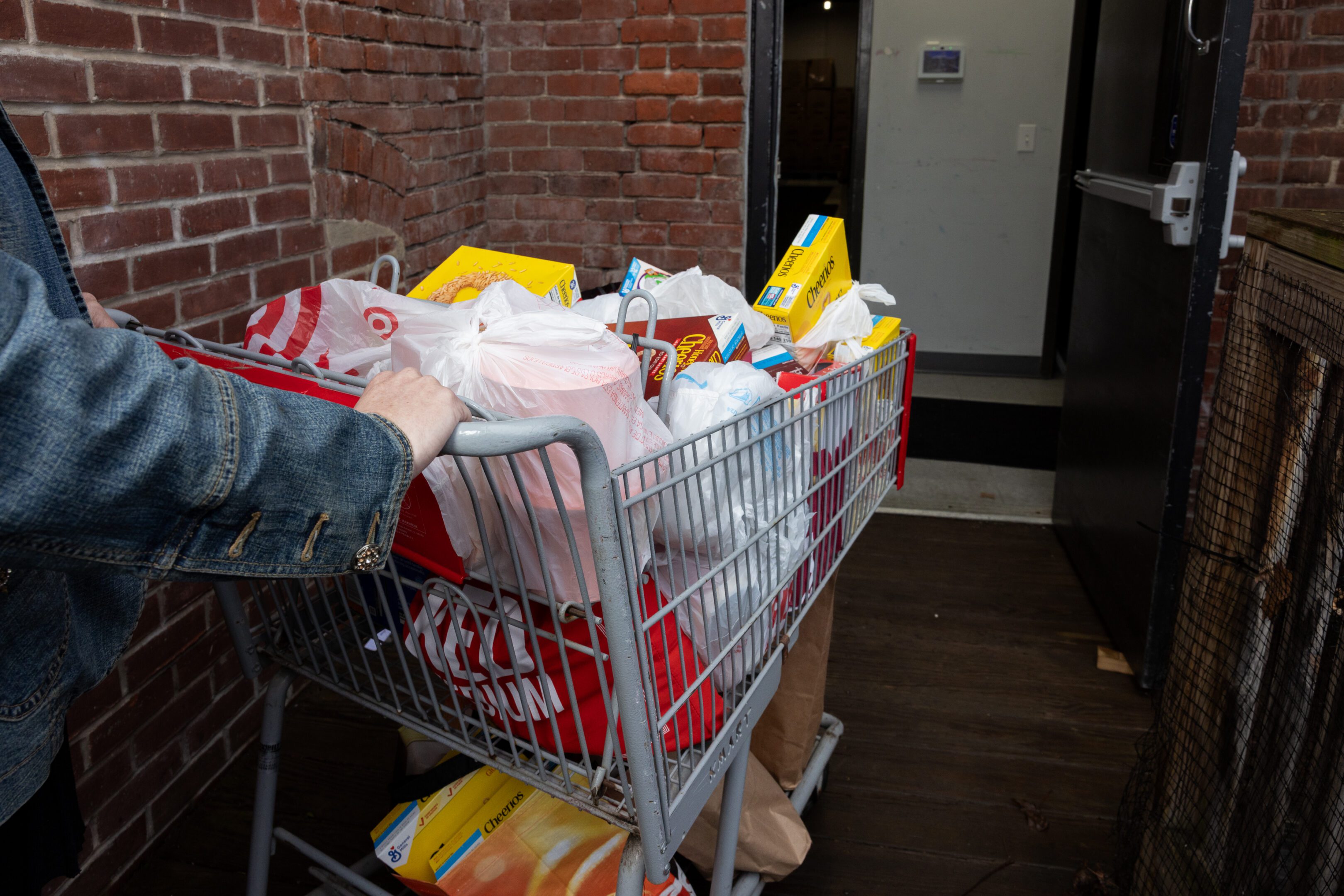 Volunteering - Giving Food A shopping cart full of food and other items.