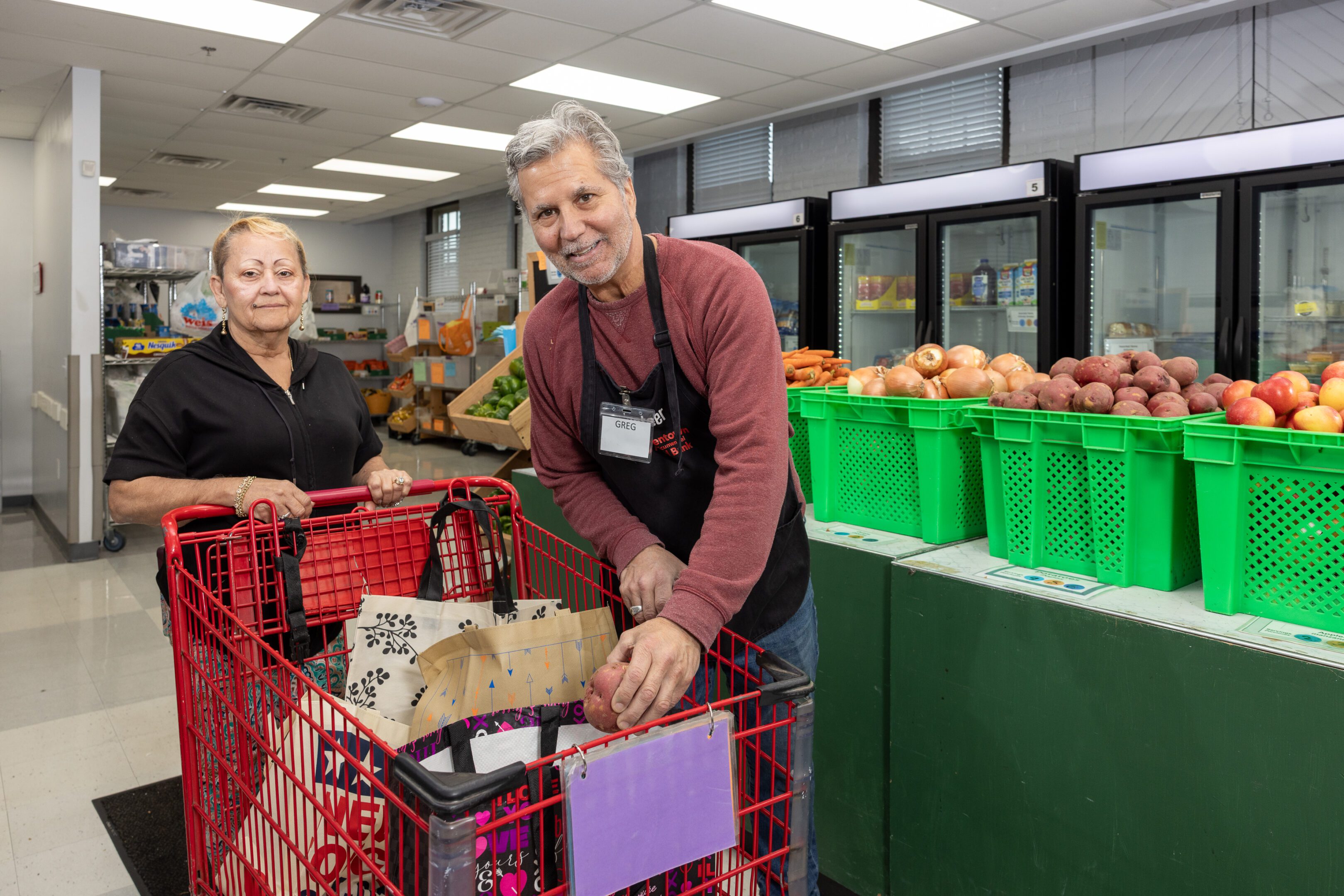 What we Do - Client Choice Pantry A man and woman in an apron with shopping carts.