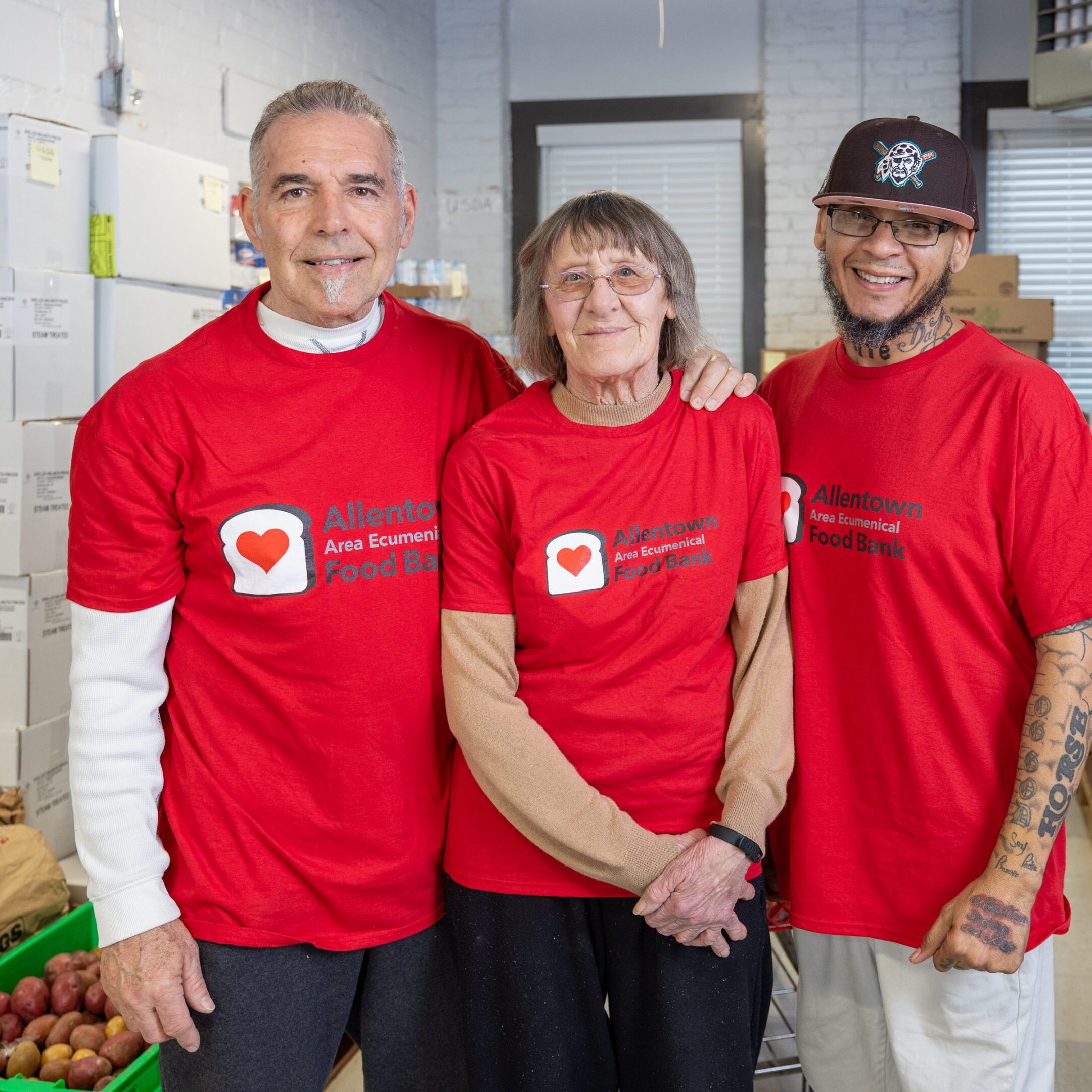 OUR TEAM MARTY, JODIE, JON Three people wearing red shirts standing next to each other.